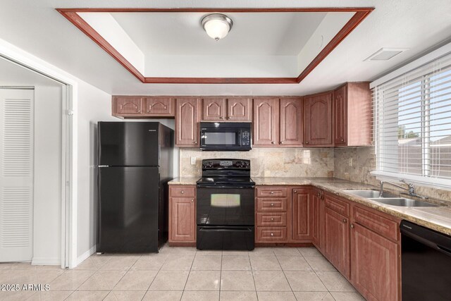 kitchen with black appliances, sink, light tile patterned floors, a tray ceiling, and tasteful backsplash