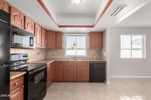 kitchen featuring light tile patterned flooring, tasteful backsplash, a raised ceiling, and black appliances