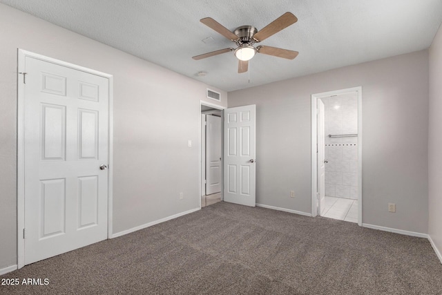 unfurnished bedroom with a textured ceiling, ceiling fan, light colored carpet, and ensuite bathroom