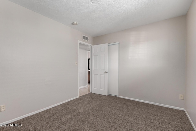 carpeted spare room featuring a textured ceiling