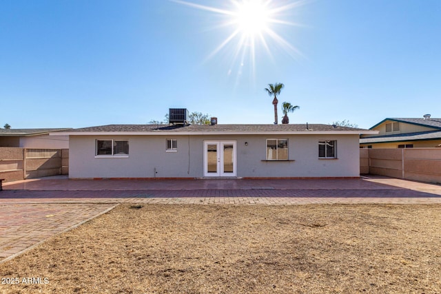 back of property with a patio area, french doors, and cooling unit