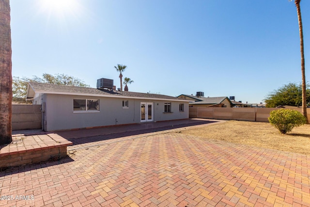 rear view of house featuring central AC unit, a patio, and french doors