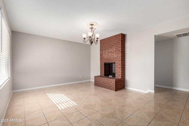 unfurnished living room featuring a brick fireplace, light tile patterned floors, and a chandelier