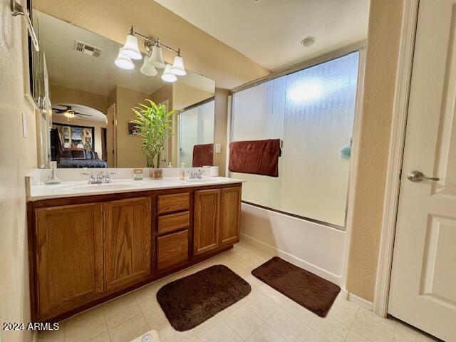 bathroom with combined bath / shower with glass door, vanity, and ceiling fan