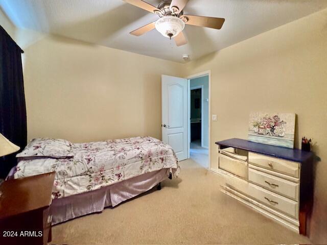 bedroom featuring light colored carpet and ceiling fan