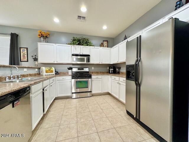 kitchen with white cabinetry, sink, light tile patterned flooring, and appliances with stainless steel finishes