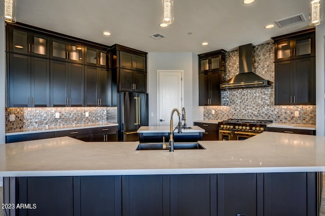 kitchen featuring sink, wall chimney range hood, backsplash, a spacious island, and high end appliances