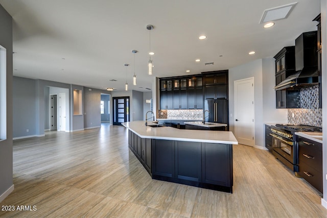 kitchen with tasteful backsplash, wall chimney exhaust hood, high end appliances, pendant lighting, and a large island