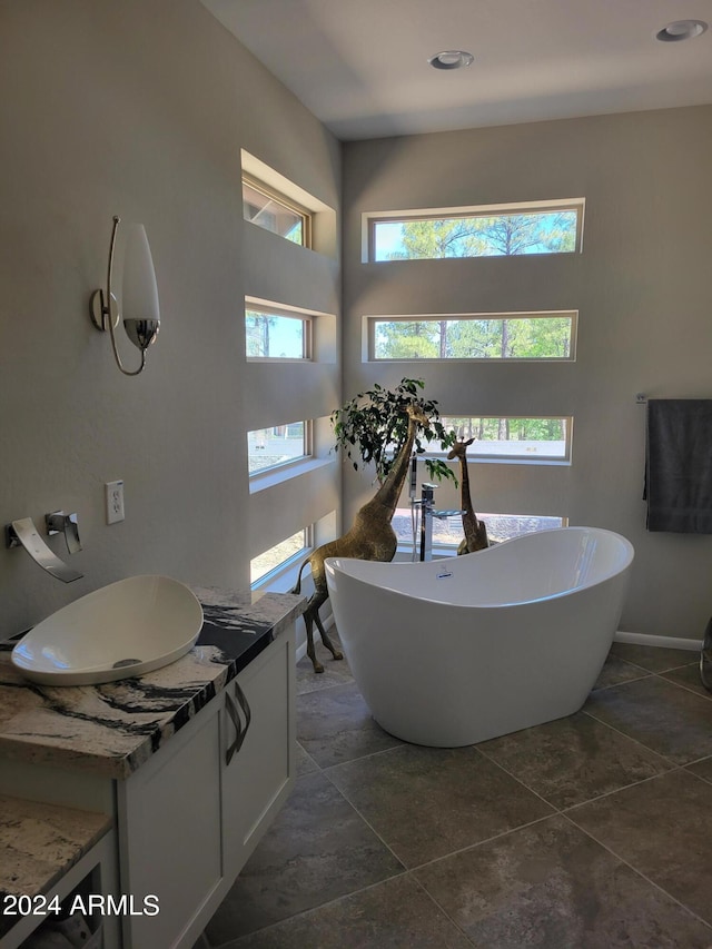 bathroom with a healthy amount of sunlight, vanity, and tile floors