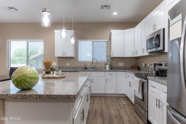 kitchen featuring stainless steel appliances, a kitchen island, visible vents, and white cabinets