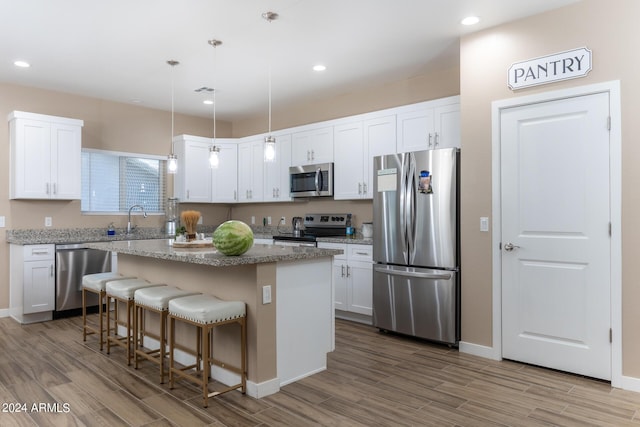 kitchen with white cabinetry, a kitchen island, and appliances with stainless steel finishes