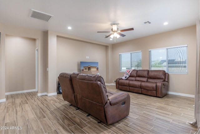 living room featuring baseboards, wood finish floors, visible vents, and a ceiling fan