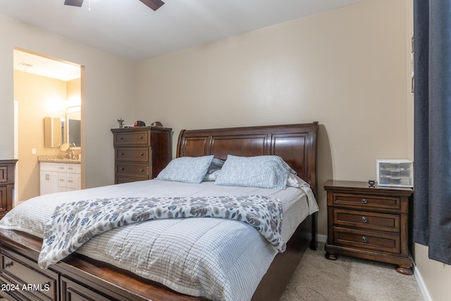 bedroom with light colored carpet, connected bathroom, baseboards, and ceiling fan