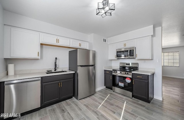 7101 N 36th Ave Unit 102, Phoenix, AZ 85051 - kitchen featuring appliances with stainless steel finishes, a sink, baseboards, and white cabinets