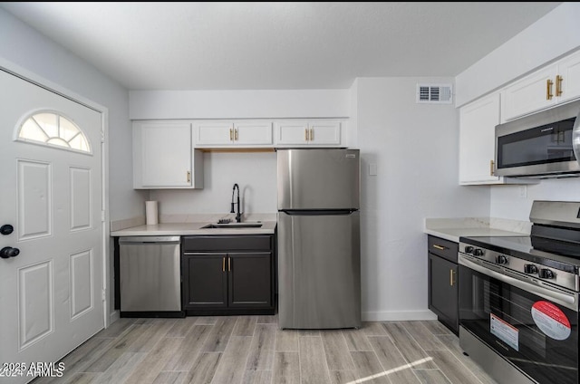 7101 N 36th Ave Unit 102, Phoenix, AZ 85051 - kitchen with appliances with stainless steel finishes, a sink, light countertops, and white cabinets