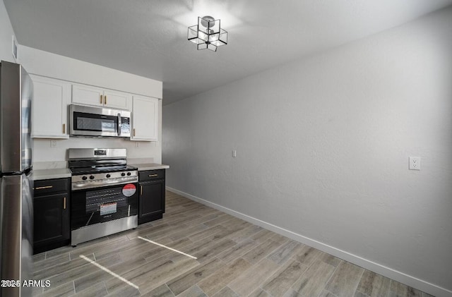 7101 N 36th Ave Unit 102, Phoenix, AZ 85051 - kitchen featuring appliances with stainless steel finishes, light wood-style flooring, light countertops, and baseboards