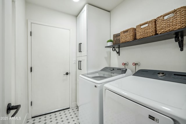 laundry room with independent washer and dryer and cabinets