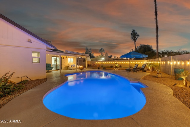 pool at dusk featuring a patio area