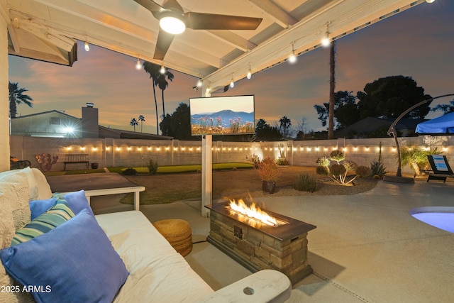 view of patio with ceiling fan and an outdoor living space with a fire pit