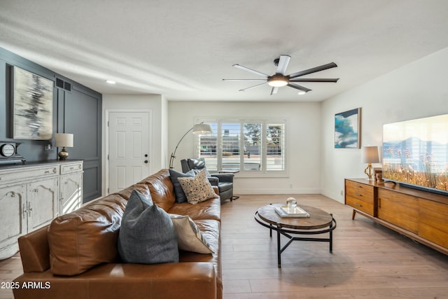 living room with light hardwood / wood-style floors and ceiling fan