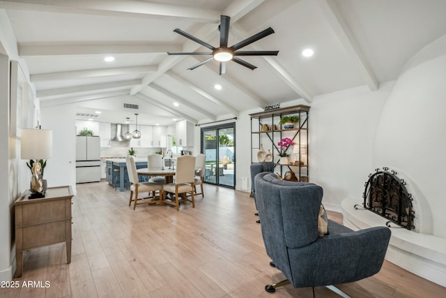 interior space featuring sink, ceiling fan, light hardwood / wood-style floors, and lofted ceiling with beams