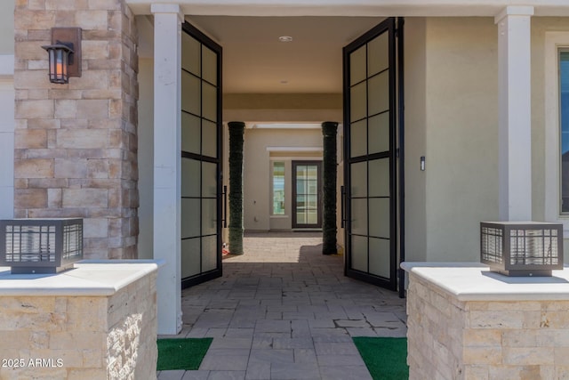 doorway to property with stucco siding and stone siding
