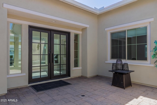 doorway to property with french doors, stucco siding, and a patio