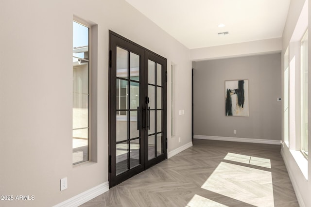 spare room with french doors, baseboards, and visible vents