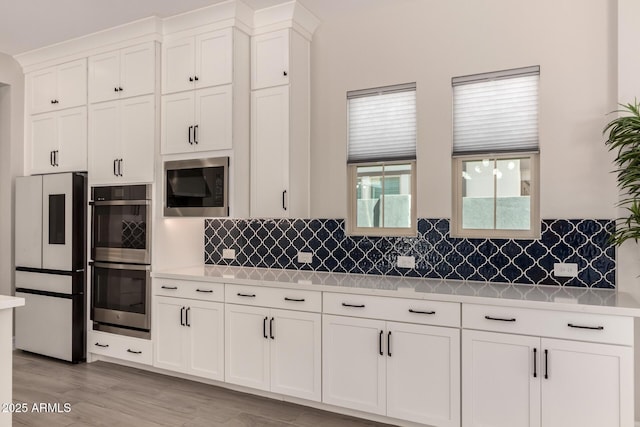 kitchen with freestanding refrigerator, light countertops, stainless steel double oven, and built in microwave