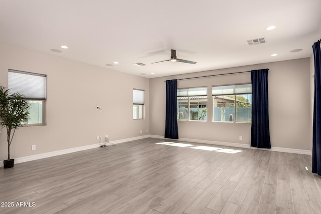 spare room featuring a ceiling fan, baseboards, visible vents, light wood-style floors, and recessed lighting