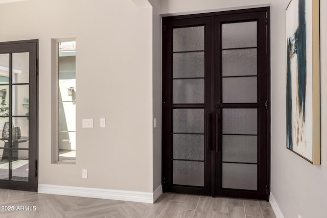 interior space with baseboards and french doors
