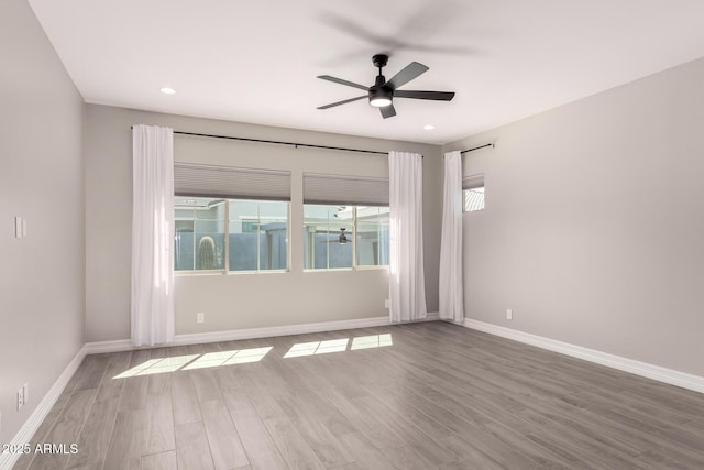 spare room with baseboards, wood finished floors, recessed lighting, and a ceiling fan