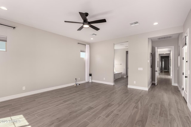 interior space with baseboards, ceiling fan, visible vents, and wood finished floors