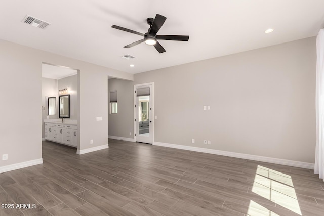 unfurnished bedroom featuring recessed lighting, baseboards, connected bathroom, visible vents, and wood finished floors