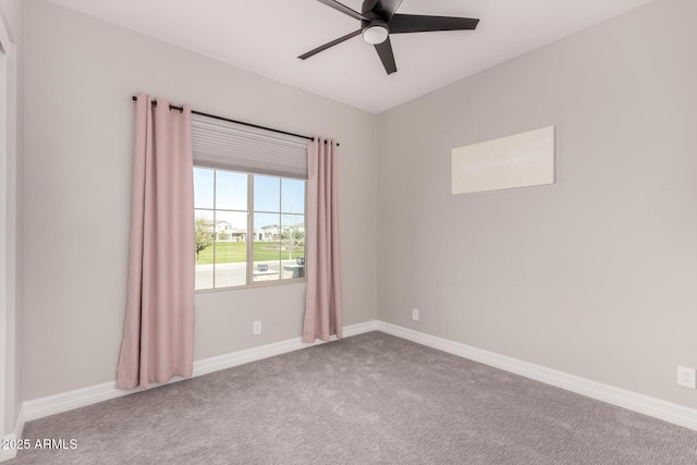 spare room featuring baseboards, ceiling fan, and carpet