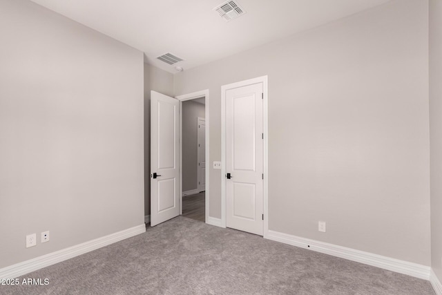 spare room featuring carpet flooring, baseboards, and visible vents