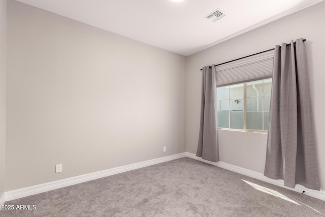 unfurnished room with baseboards, carpet floors, and visible vents