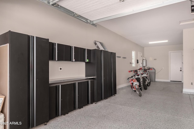 garage with baseboards and freestanding refrigerator
