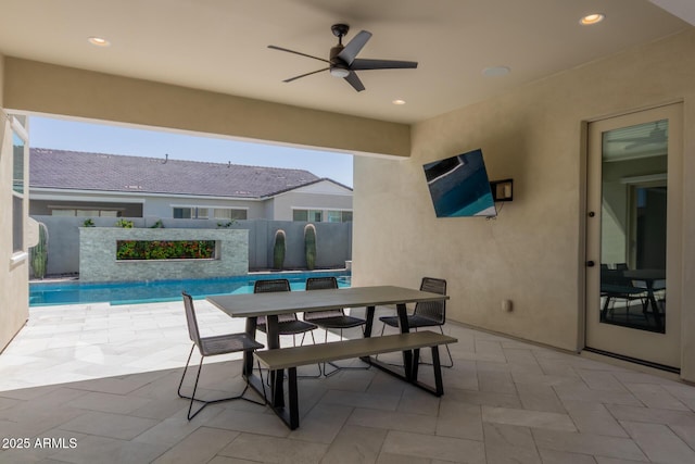 view of patio featuring a ceiling fan, outdoor dining area, and fence