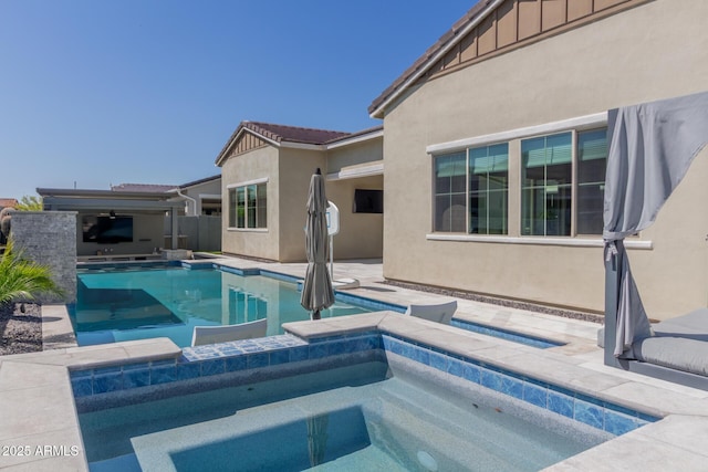 pool with a sink, an in ground hot tub, and a patio area