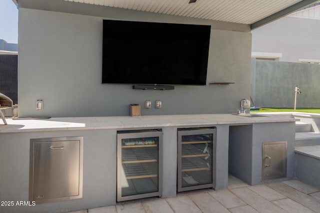 view of patio / terrace with exterior kitchen, a sink, and wine cooler