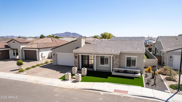 view of front facade featuring a tile roof, stucco siding, an attached garage, stone siding, and driveway