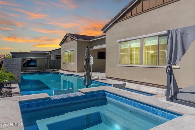 view of pool featuring a patio area, a sink, a fenced in pool, and an in ground hot tub
