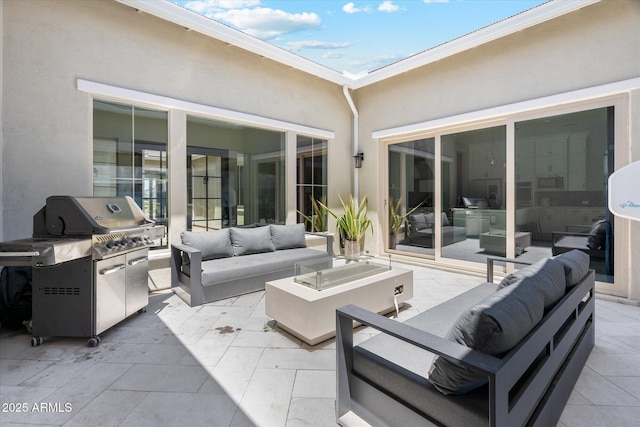 view of patio with grilling area and an outdoor living space with a fire pit