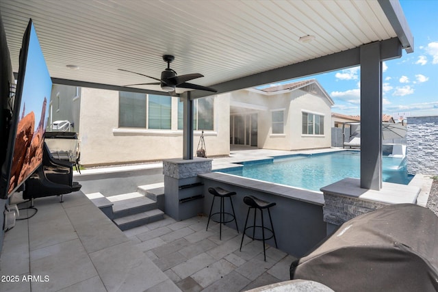 pool featuring ceiling fan, fence, outdoor dry bar, and a patio area