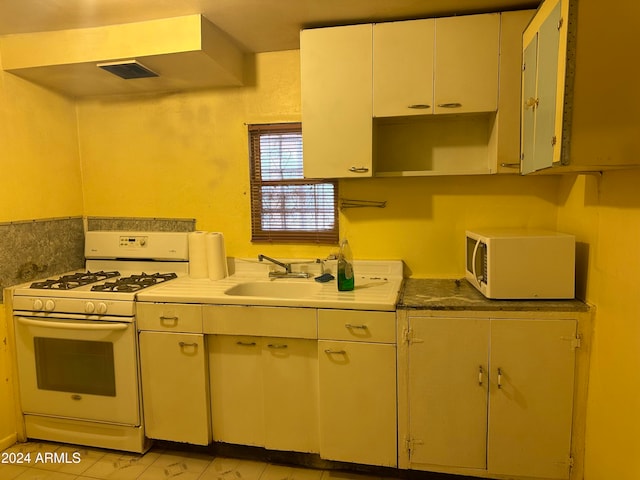 kitchen featuring white appliances, light tile patterned floors, and sink