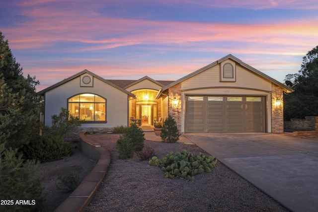 single story home featuring stone siding, driveway, and an attached garage