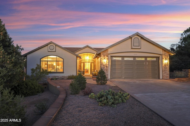 single story home featuring stone siding, driveway, and an attached garage