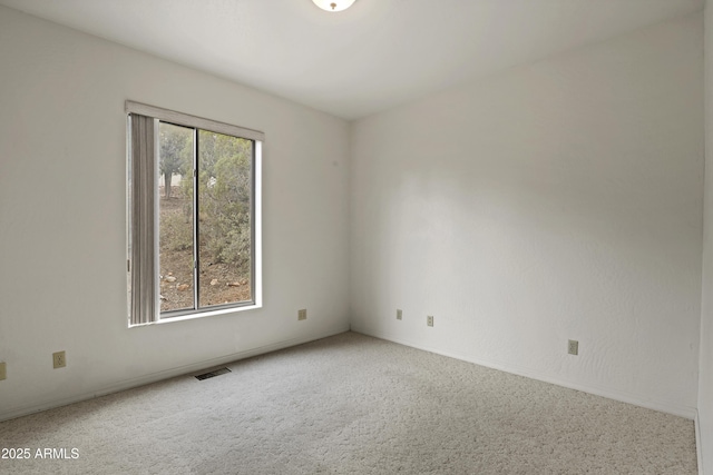 unfurnished room with visible vents and carpet flooring