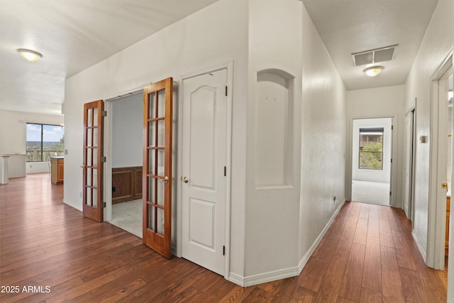 hall with visible vents, dark wood finished floors, and french doors